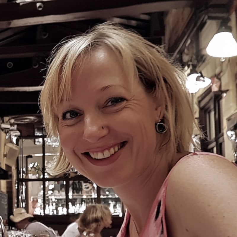 Woman smiling in a casual setting with blurred background